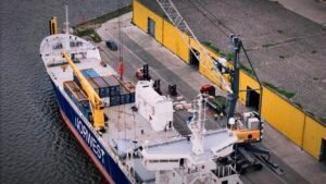a breakbulk liner ship being loaded at port with oversized and heavy cargo
