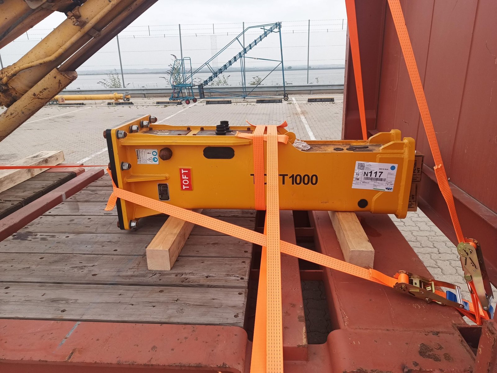 Hydraulic hammer supported on timber and secured with lashing straps on the London Gateway flat-rack