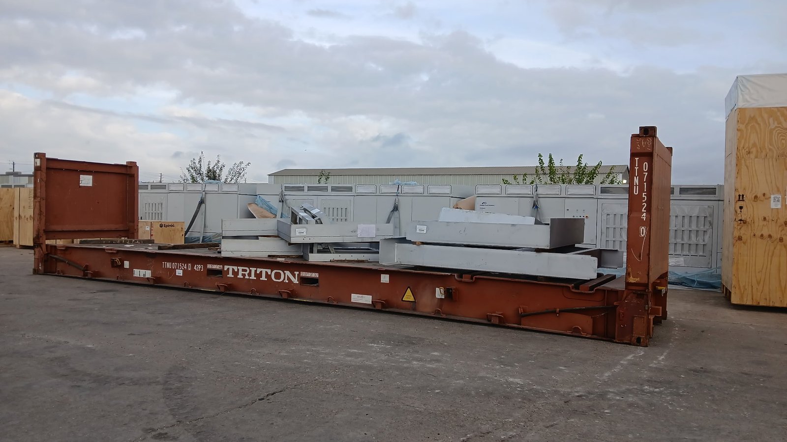 Furnace steel fabrications on a 40-foot flat-rack in a Houston-area yard before US road delivery